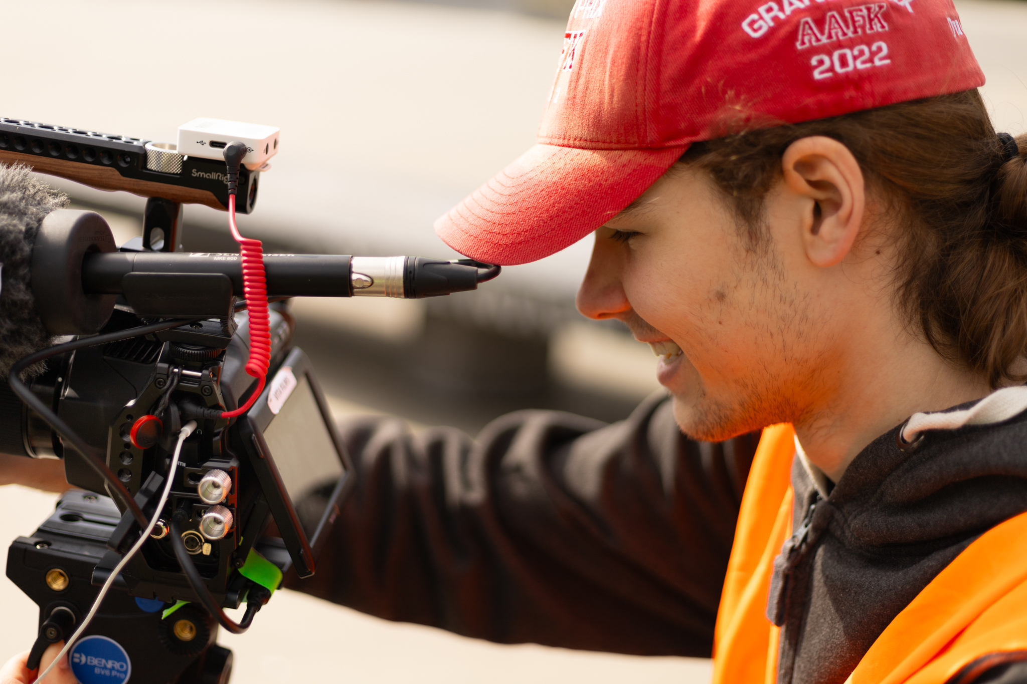 a man in a red hat smiling while filming